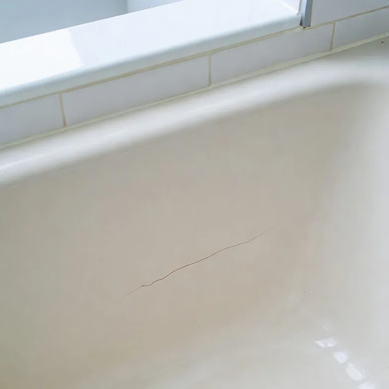 Cracked fiberglass bathtub before repair